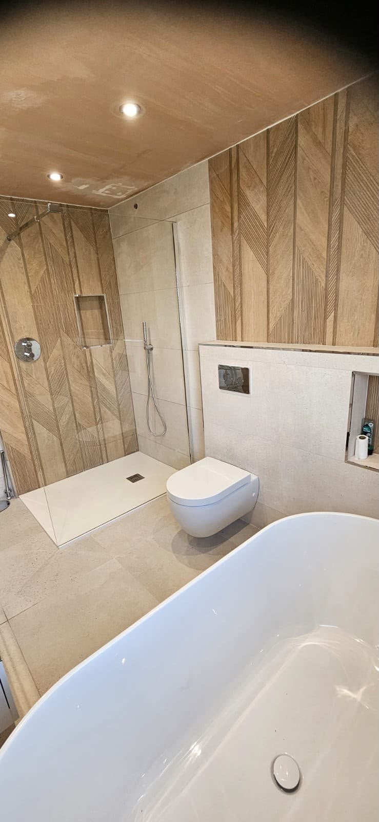 Contemporary walk-in wet room with precision tiling and mosaic detailing